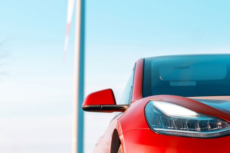 A red car against a blue sky